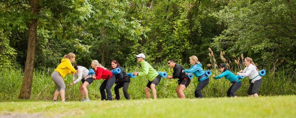 groupe de personne pratiquant du cardio plein air avec une coach